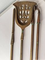 Full view of the three brass fireplace tools hanging together