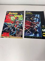 Both comic book covers side by side on tabletop