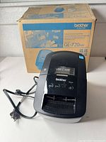 Printer with power cord in front of original box