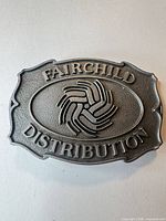 Front view of buckle showing FAIRCHILD DISTRIBUTION text and logo