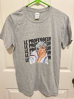 Front view of T-shirt on hanger displaying graphic and overall condition