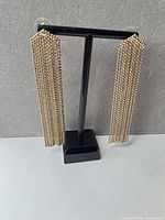 Front view of both tassel earrings on stand