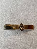 Front view of gold-tone tie clip with USN anchor emblem