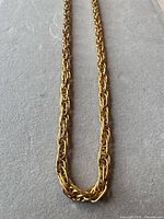 Full view of gold-tone rope chain necklace laid flat
