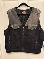 Full view of vest front showing leather shoulder yoke, zipper, pockets