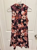 Front view of dress on hanger showing floral pattern and silhouette