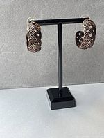front view of Celtic braided hoop earrings on stand