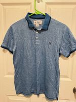 Front view of light blue polo shirt on hanger