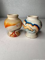 Front view of both Nemadji vases showing swirl colors and pedestal bases