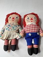 Front view of both cloth dolls displaying clothing, faces, size