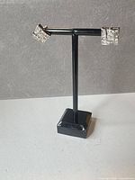 Full view of both earrings on stand