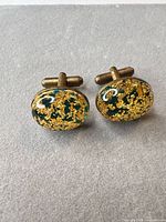 front view of both cufflinks displaying green resin with gold foil