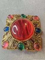 Front view showing full brooch design and cabochons