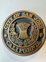 Front view of round brass-tone City of San Jose California belt buckle