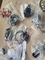 Overview of several clear bags containing assorted jewelry pieces