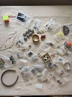 Overview of all jewelry pieces in individual bags on fabric surface