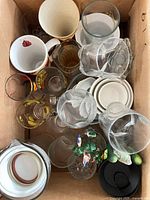 Top view showing assorted glasses, mugs, ramekins, pitcher lid, ornaments