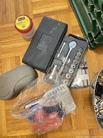 Jar, black tool case, blister socket set and bag of hardware on floor