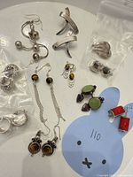 All jewelry pieces laid out showing designs, stones and metal tone