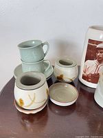 Group showing green cups, lidded pots, saucer, stein