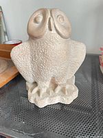 Front view of textured concrete owl figurine
