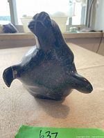 Front angled view of dark green soapstone seal carving