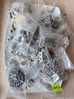 Top view of assorted jewelry in individual bags on tray