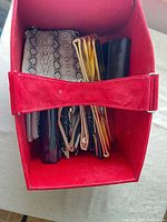 Red box containing assorted clutches and wallets
