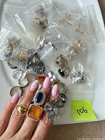 Overview of individually bagged costume rings on tray with sticky note