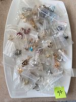 White platter holding numerous small zip-lock bags, each containing individual costume rings