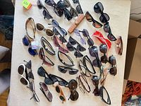 All sunglasses spread out on table showing quantity, styles, colors and materials