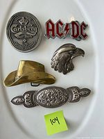 Overview of five metal buckles on white surface