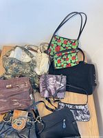 Group shot of all nine assorted handbags on table