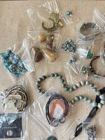 assorted bagged jewelry including fish pendant, cuff, earrings, bead necklaces
