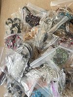 Multiple zip bags containing assorted bracelets and necklaces