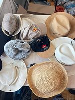 Top-down view showing straw, cotton, faux-fur, baseball, fedora and cowboy hats on table