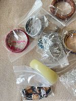 All bracelets bagged showing wood, plastic, resin, and silver-tone rhinestone pieces