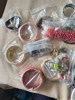 Lot overview showing bangles, bracelets, and bead packets in clear bags