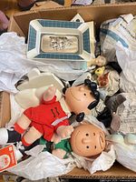 Box showing Peanuts dolls, ceramic ashtray, figurines