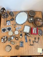 Full overview of mixed silver & metal decorative items spread on table