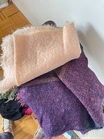 Pink and purple scarves folded on chair