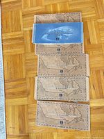 Stacked coin presentation folders showing four brown 1999 map-design and one blue 2000 folder