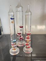 Front view of all three thermometers showing varying heights and internal floats