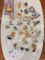 Overview of all bagged brooches, earrings and cufflinks on white board
