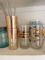 All drinkware items grouped on shelf showing graphics, colours and condition