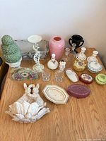 Overall view of assorted porcelain, milk glass and clear glass decorative pieces on tabletop