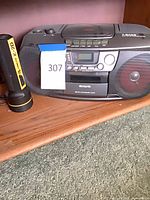 Front view of Aiwa CSD-TD901 boombox with Lumilite K-2D handheld device beside it