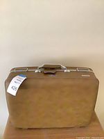 Full view of brown hard-sided suitcase standing upright