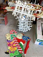 Overall lot with metal cart full of white stakes and striped tubes, cutout figures on floor