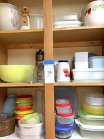 Shelved assortment of Tupperware containers, milk glass jug and ceramic pitcher